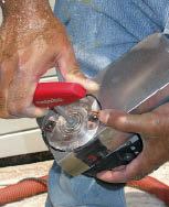 To change the depth-of-cut, the author raises or lowers the head by locking the spindle and using a spanner wrench to turn a screw in the bottom of the tool.