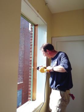 After taking out the sash, the quickest way to remove the old frame and exterior trim is by cutting through it with a reciprocating saw.