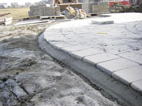 Mortar trowelled along the edge of the soldier course serves as an edge restraint. The author has found that this detail holds up well to freeze-thaw cycles. 