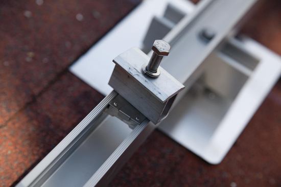 The clips fit between adjacent modules, securing them to the rails and ensuring a consistent edge-to-edge spacing. Slightly different fittings are installed at the end of each rail.