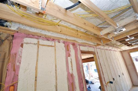 Potential leak points in the framing of this partition between a living space and garage were sealed with sprayable caulk before the foam sub sprayed the cavities and overhead roof deck. Ductwork will be installed in the conditioned space between the roof deck and ceiling, which should improve the performance of the home’s air conditioning and heating.