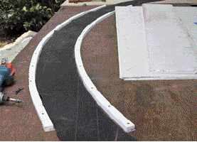 To make a form for the trim, 1-inch-wide PVC rippings are screwed to the worktable, with the felt-paper template serving as a guide.

