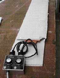 The PVC trim is warmed with heat blankets; scraps of drywall prevent heat loss and speed up the process.