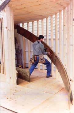 He then installs the stringer laminations, aligning the top edges with the marks and gluing and screwing them together.