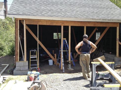 The wider overhead door required the installation of a double 11 7/8-inch-deep Microllam header under the existing 4x4 top plate. A screw jack was used to level the opening and to support the beam until jack and king studs could be installed.