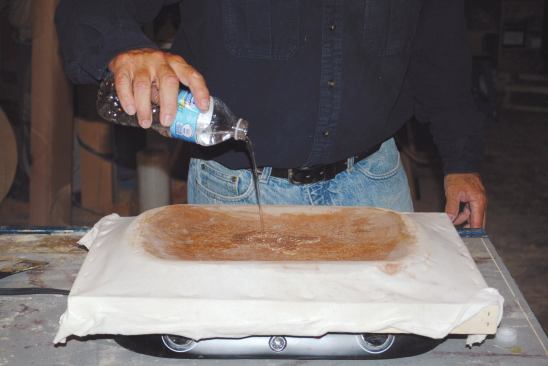 I set the cloth frame over the roasting pan and pour some more water over the cloth to dampen it.