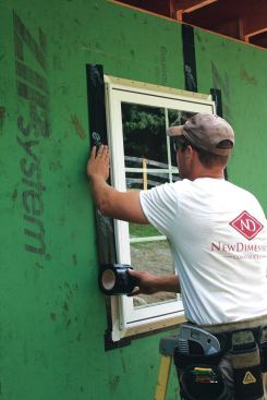 With the windows in place, we applied a strip of tape at each jamb, running it about 3 inches above and below the window frame.