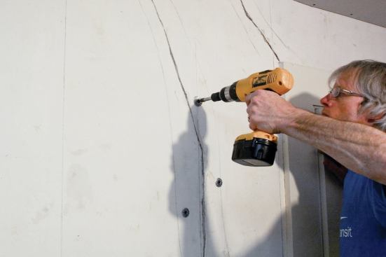 Fastening with 2 1/2-inch screws into the studs clamps the plaster under the washers. If the spaces between washers are still spongy, attach the washers to the lath with 1 1/4-inch drywall screws.