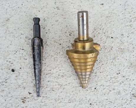 Step drills work great on steel and allow one bit to drill holes of several sizes.