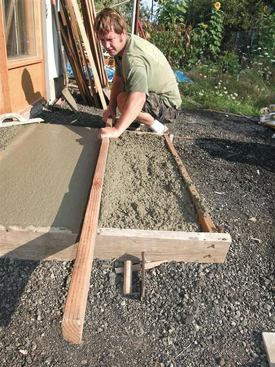 Concrete is leveled by screeding — sliding a straightedge back and forth across the forms while moving it forward.