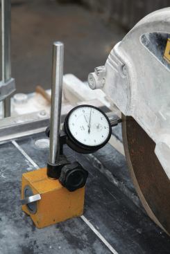 IS THE BLADE OK?

This tool, called a dial indicator, can measure very small amounts (in thousandths of an inch) of side-to-side movement in the blade as it rotates. I attach the tool to the saw’s sliding table and then clamp the table itself to keep it completely stationary (5). Then I turn the blade slowly by hand while reading the face of the gauge. The pointer on the dial shows exactly where and how much the blade is moving. The blade will cut smoothly if side-to-side movement is less than five thousandths of an inch (.005 inch). Any movement greater than that and you risk breaking tiles. The blade can also distort if its rim overheats, which can happen when a regular blade is used to cut porcelain tile. Expansion slots on a porcelain wet-saw blade allow the blade’s rim to expand without distorting the blade (6). If you don’t have a dial indicator and tiles are splitting as the blade nears the end of the cut, unscrew the nut and washer to see if there is any grit on the spindle or clamping washers that could throw the blade out of plane. If the components are clean, the blade probably needs to be replaced.