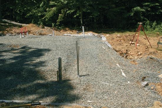 Once the utilities passed inspection, I backfilled and compacted all the disturbed areas, then spread a 6-inch-thick layer of 3/4-inch crushed stone everywhere, which I also compacted.