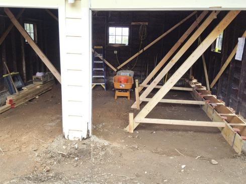 New 14-inch-deep footing forms were set at the same height as the existing slab and tied back to the diagonal bracing.