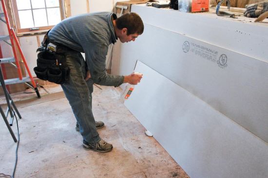 Workers sprayed both sides of each panel with a mister. Allowing the wet panels to sit for a few minutes before installation increased their flexibility even more, making it easier to form the flexible drywall to the 12-inch radius of the cove.
