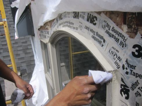Around windows and doors, care needs to be taken to integrate flashing tape and housewrap. On the sides and bottom, the flashing should lap over the housewrap; but at the head, the housewrap should lap over the flashing.