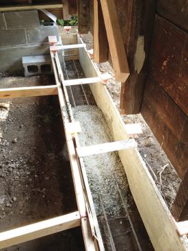 Similar to the gable-end footings, two continuous #5 rebars were placed at the bottom of the footing. The rear footing was pinned to the gable ends with two #5 rebar pins drilled and epoxied into place.