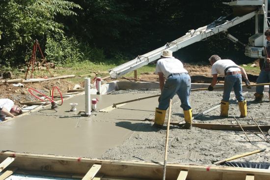 After being screeded, large slabs are flattened with a bull float. Bull-floating also pushes the coarse aggregate down and brings up the finer, more easily finished “cream.”