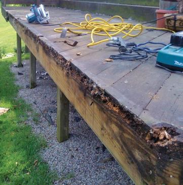 On this deck, debris trapped behind a flush fascia held moisture, which led to rot in the decking and trim.