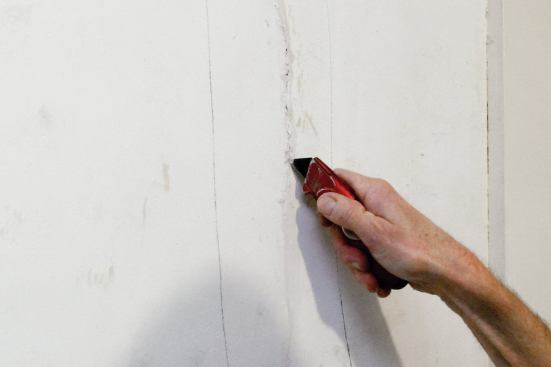 Slice open each plaster crack with a utility knife.