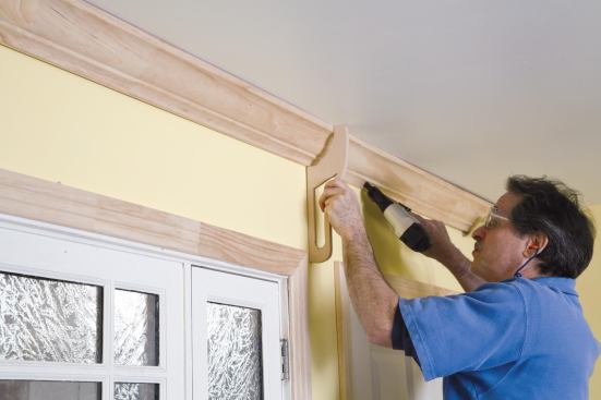 Then he moves to the center of the wall, using the crown holder for accurate placement.