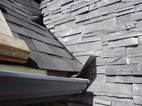 Note the small cricket at the end of the valley above the kick-out. This is a variant of the kick-out and it performs the same critical task of diverting water away from the walls.