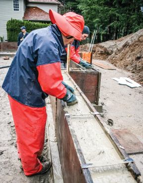 Even though the mix from the line pump is smooth and easy to work with, the author’s crew still spends a few moments flattening out the concrete and patting down stray aggregate while installing hardware.