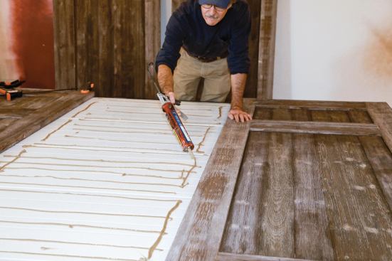 Once the carriage doors were assembled, the author spread construction adhesive on the steel door panels.