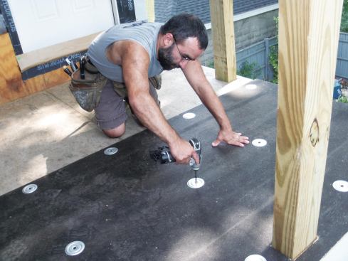 To protect against fastener show-through, the author added a layer of wood-fiber recover board, fastened to the structural deck with the same reinforced galvanized screw plates and 1 5/8-inch screws used to secure the TPO membrane.