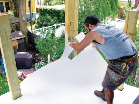Cutouts in the membrane allowed it to slip over the tops of the posts, minimizing seams; an open cutout at the outside corner column accommodates the membrane turn-down along both edges.