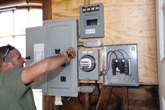 At the service entrance, the metal-clad cables from the array can just be seen here entering the subpanel at top center. Because the power from the panels has already been converted to AC and synchronized with the grid at each microinverter, there’s no need for a large synchronous inverter between the PV subpanel and main breaker box at far left. The utility-grade meter at center tracks the array’s power production. The additional box to the right of the meter will contain a data acquisition system, or DAS, which will automatically track production of solar renewable energy credits (SRECs) and send that information to a third-party meter reader.