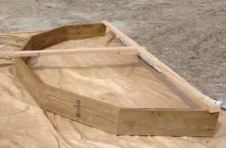 Figure 2. The lengths and miters of the band board's parts are ciphered on a calculator. To prevent the mitered band-board assembly from tweaking while it's being handled, 2x4 braces reinforce the desired shape.