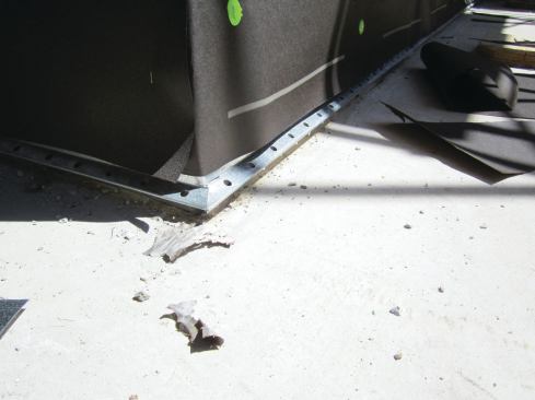 After installing the weep screed, we cover the walls with housewrap and building paper ...