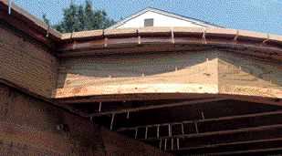Figure 7. Notched to bend, an aluminum drip edge is installed below the decking to prevent streaking of the fascia. Bituminous roofing membrane on the joists prevents direct corrosive contact, and more membrane atop the drip edge seals the notches.