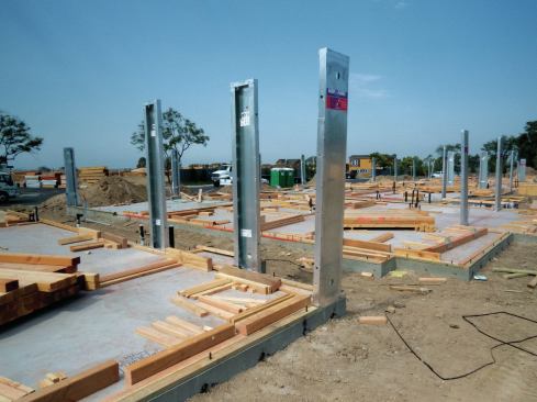 Framers typically set panels before they stick-frame the surrounding walls; here, panels stand alone on a slab waiting for walls.
