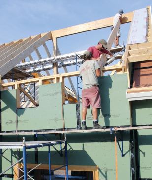 Crew members tacked the dense material in place with a nail gun, then used impact drivers to drive structural screws through the rafters into the framing.