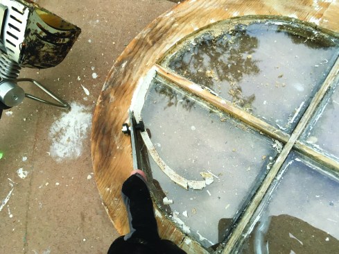 Once softened, the glazing putty can be easily peeled away from the window frame. Note: while not required on this job, aluminum foil can be used to shield
historic glass.
