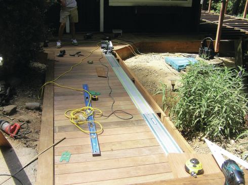 Makita and Festool tracks can be connected to make a very long rail. For even longer cuts, the author snaps a chalk line and aligns the track edge with the line. Clamps can be used to lock tracks in place but aren’t usually needed thanks to soft rubber friction strips on the bottom of the tracks, which grip the cutting surface. 