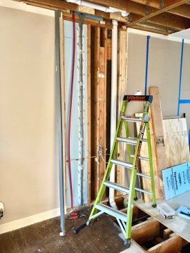 Before running new supply lines in the exterior wall, the author insulated the bay with rigid foam.