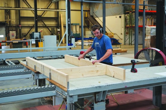 Alex Morin assembles the framing for a window rough opening. This component will then get fed into the automated framing system that will frame the other parts of the wall.