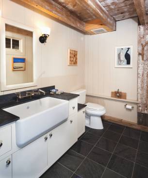 Low shelves flanking the toilet take the place of grab bars. A swing-out faucet with lever handles is practical as well as accessible.