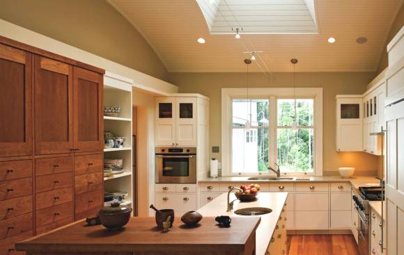 A large central skylight makes this kitchen a magnet for guests and is a boon for cooks with aging eyes.