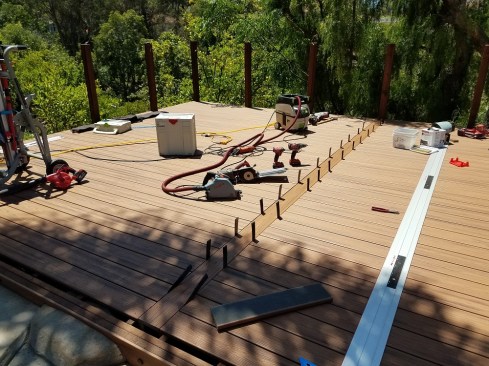 You can avoid the need for butt joints by installing a seam board in the middle of a wide deck. Here, shims were used to create a gap between the seam board and the ends of the deck boards.