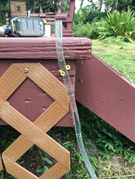 With the water in the tubing adjusted to reflect the top of the ledger and one end of the tubing secured to the framing with a pair of screws, the author was able to refer to the other end as he jacked the framing up to level.