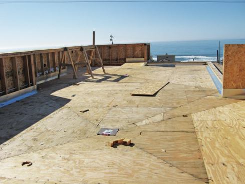 This large rooftop deck features two center drains, and was framed to slope the sheathing toward the drains. Most roof-covering manufacturers require plywood rather than OSB sheathing as a substrate. 