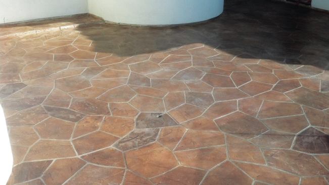 Another option for cementitious coatings is to apply a stamped and stained finish to the deck, using heavy rubber templates laid into a wet skim coat of polymer concrete over the base coat to create the pattern.