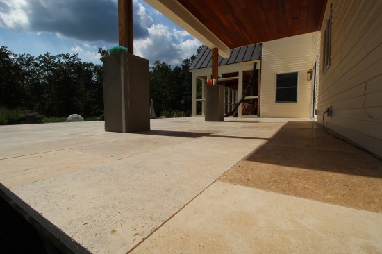 The lower deck is finished with travertine stone that was glued around the perimeter to the steel framing with two-part epoxy. In the field, the pavers were dry-laid, and the joints filled with polymeric sand.