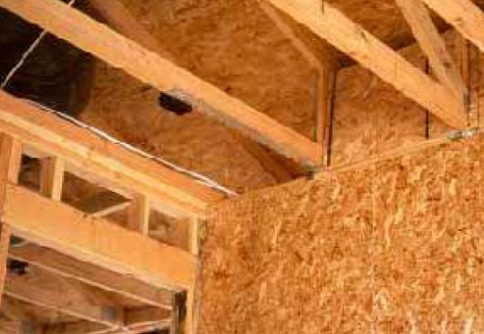 In House A, which was built according to the stamped plans, the section of roof in the small front-facing gable is tied by a strap running from a shear wall at the corner of the house to a collector truss running in the same direction.
