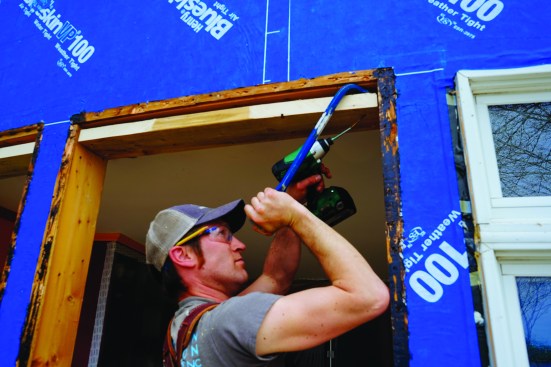 After pulling out three windows, Pollard and Strout set about replacing them. The rough openings needed a little tweaking: Strout packed down the window rough head using a 2x6 and some structural screws.