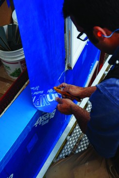 He peeled the backing paper from the adhesive backing as he went, and cutting and wrapping the material to fit.