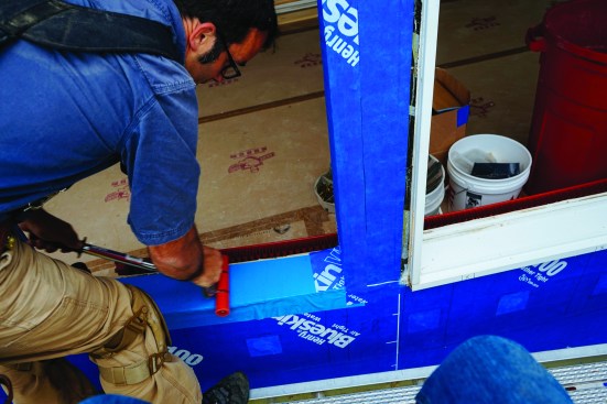 Then he applied pressure to all the membranes with the roller to activate the material’s adhesive and improve the bond. The reverse lap at the window head is allowed by the manufacturer’s spec, but a bead of silicone caulk is recommended at the joint.